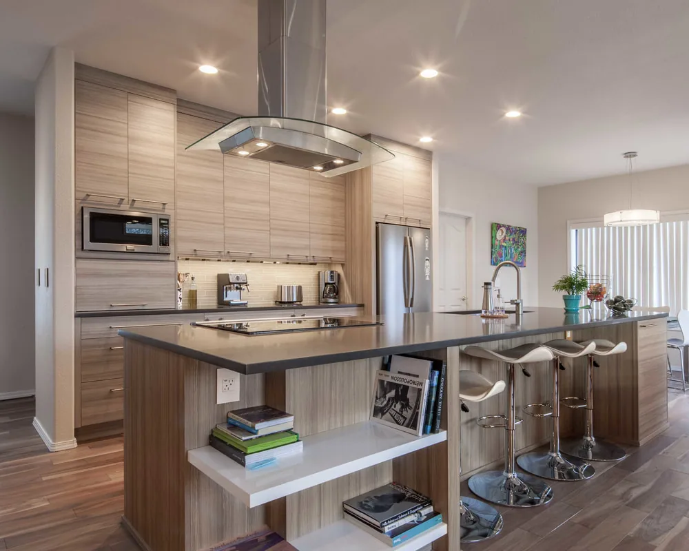 Contemporary kitchen blow-out with light wood grain and glass range hood