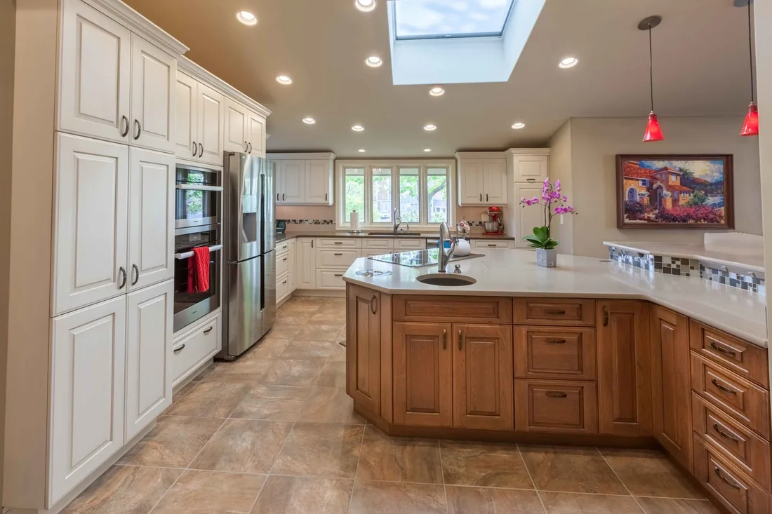 Greg and Marta's kitchen — bright white cabinets with skylight and wood island